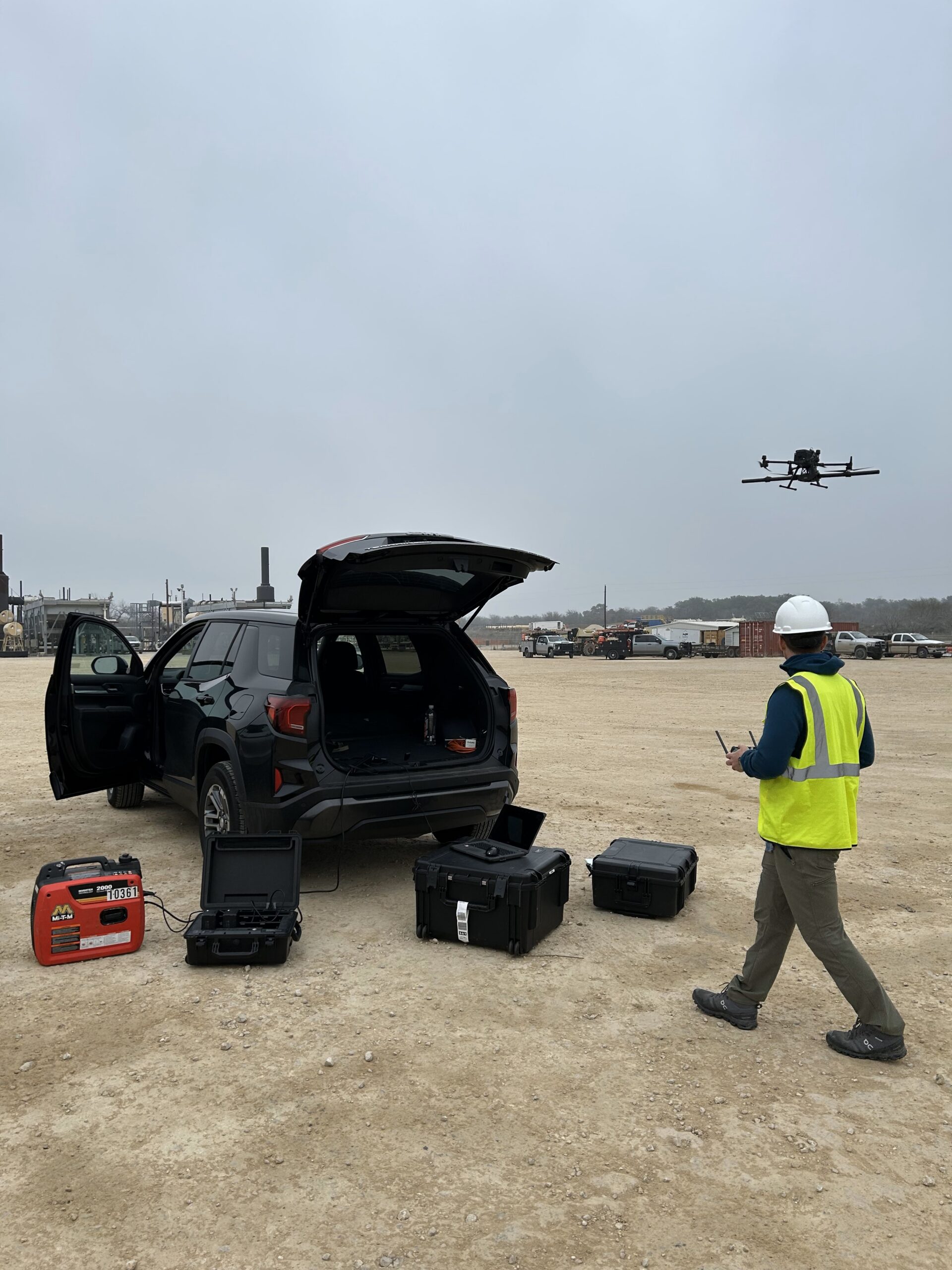 Drone pilot flying a mapping drone from a field staging area