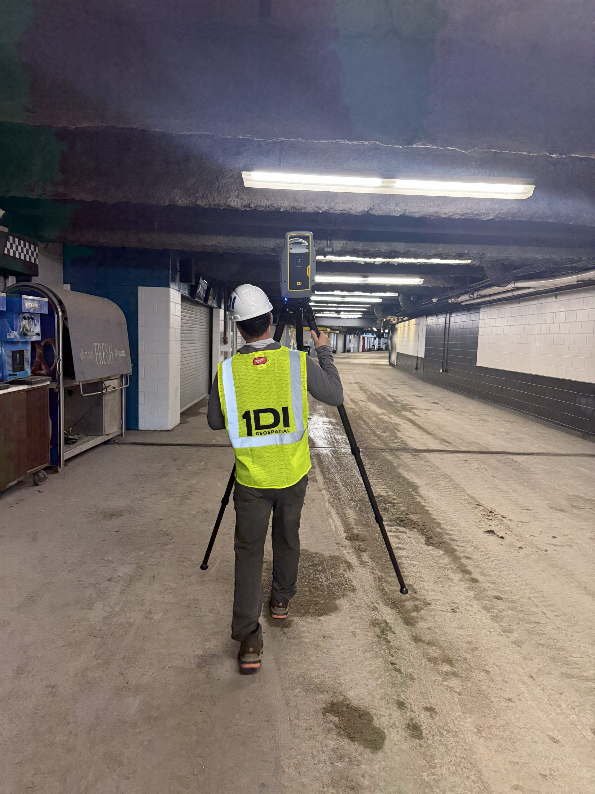 1DI Geospatial technician carrying a terrestrial laser scanner through a tunnel
