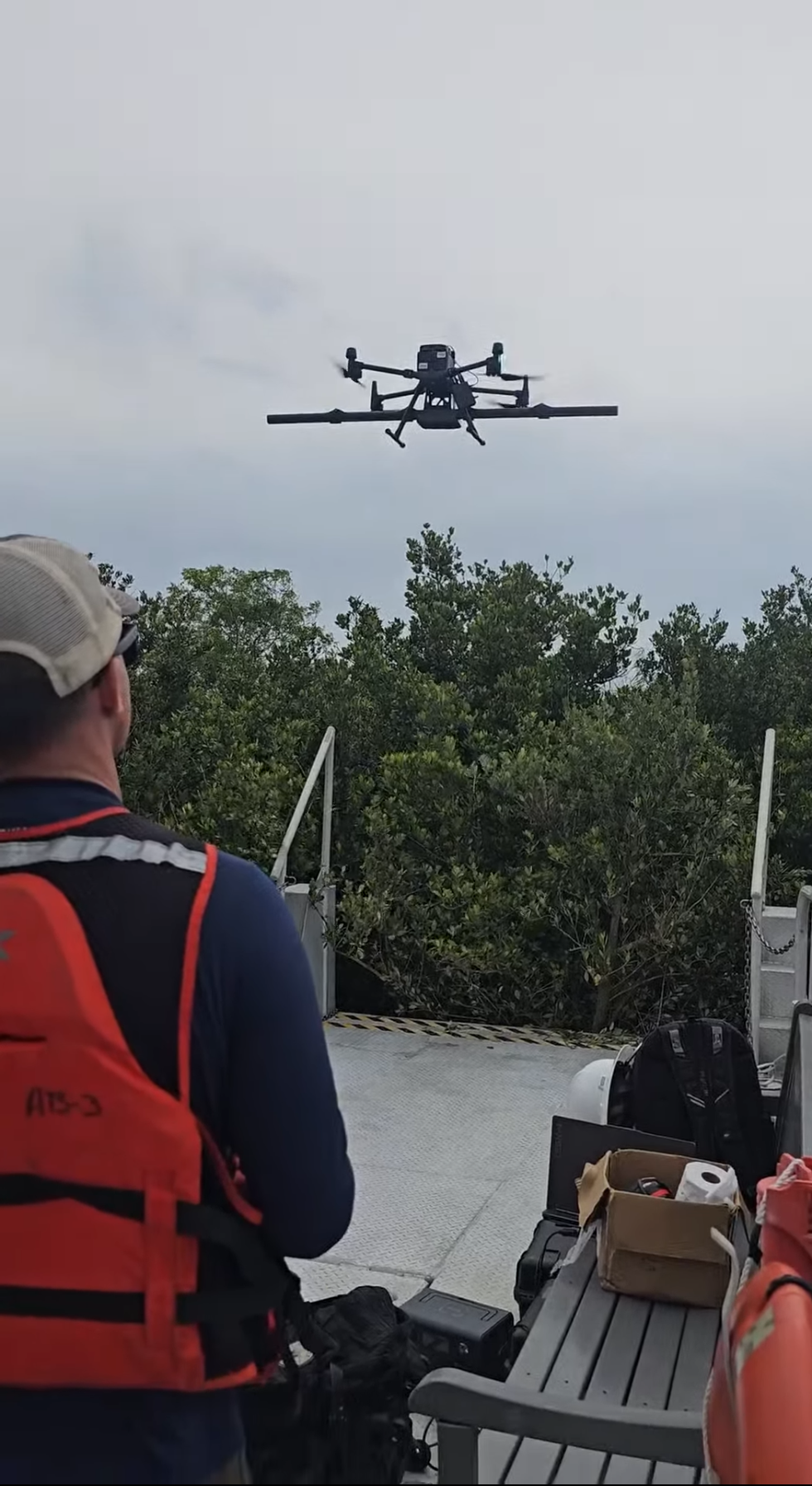 Drone with a magnetometer boom flying from a boat during a magnetometry survey